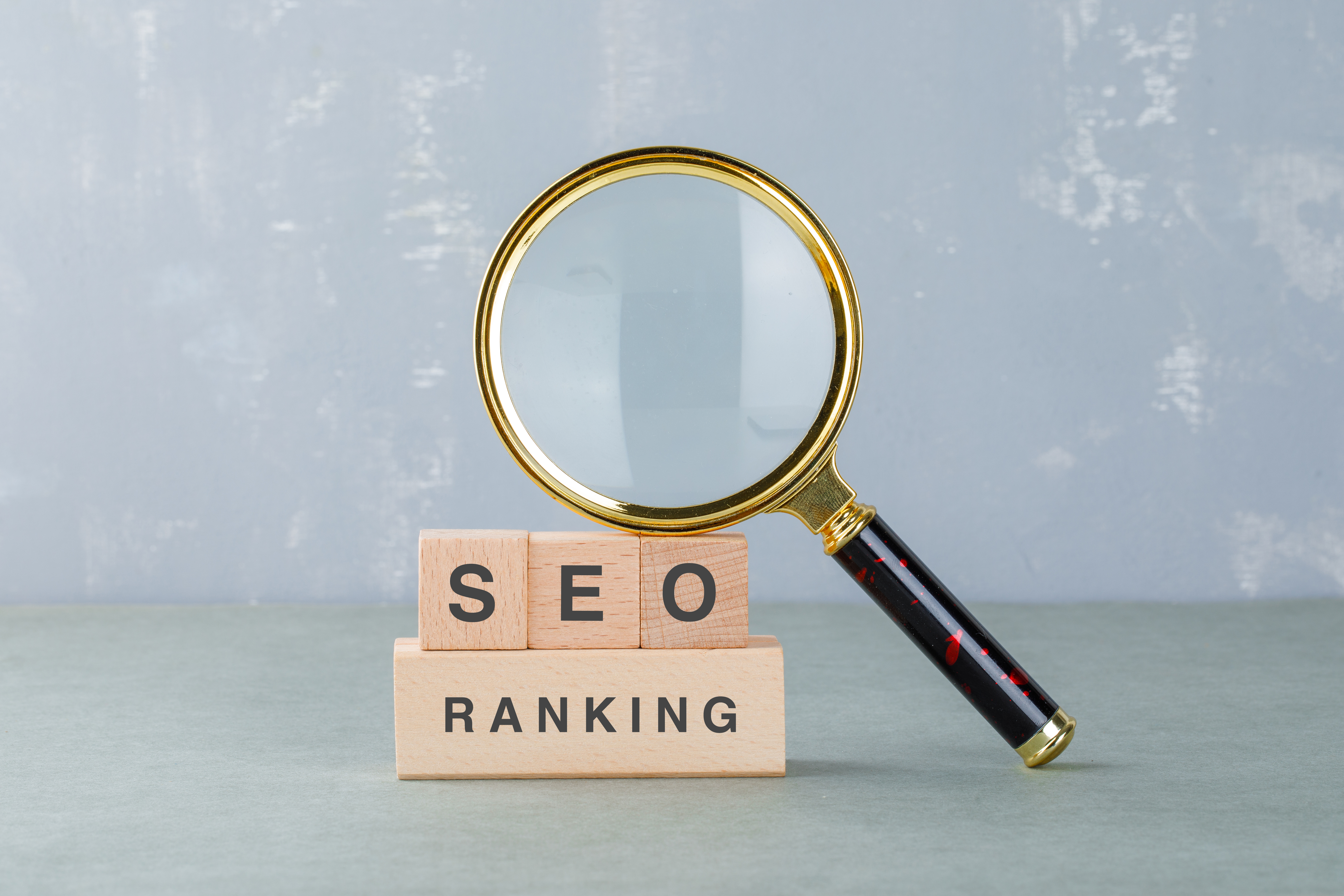 Conceptual of seo analysis and business. with wooden blocks with words on it, magnifying glass on sage color background side view